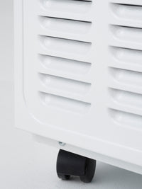 Close-up of a white dehumidifier with a black wheel on a light gray background